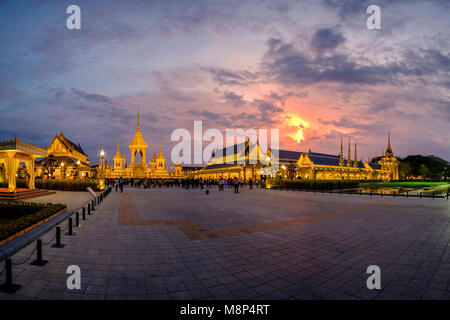 Persone in lutto sedersi di fronte al royal illuminato crematorio e complesso funebre dopo la morte del re Bhumibol Adulyadej di notte Foto Stock