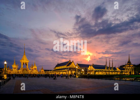 Persone in lutto sedersi di fronte al royal illuminato crematorio e complesso funebre dopo la morte del re Bhumibol Adulyadej di notte Foto Stock