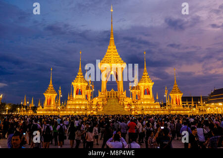 Persone in lutto sedersi di fronte al royal illuminato crematorio e complesso funebre dopo la morte del re Bhumibol Adulyadej di notte Foto Stock