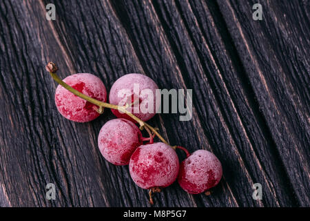 Le bacche di ribes rosso in un gelo la vista superiore giace su un sfondo di legno Foto Stock