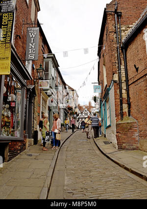 Lincoln: Vista lungo la Ripida collina acciottolata dal castello e dal fine della cattedrale; molti negozi e boutique prevalgono. Foto Stock