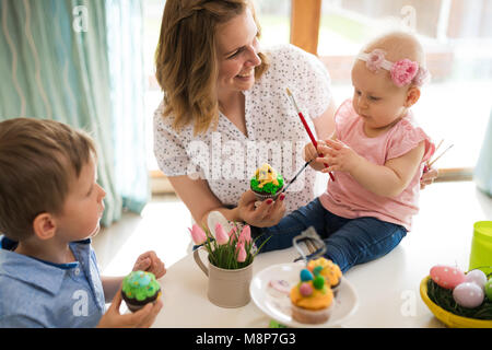Madre e figli di pittura delle uova colorate Foto Stock