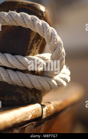 La corda avvolta attorno a un tassello di legno su una barca da pesca Foto Stock