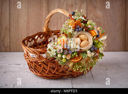 Cesto di pasqua. Cesto di Pasqua decorate con fiori e composizione di uova di quaglia Foto Stock