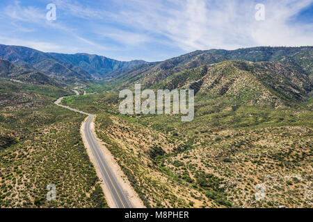 Strada asfaltata si snoda attraverso le colline e i canyon della California del sud Mojave Desert. Foto Stock