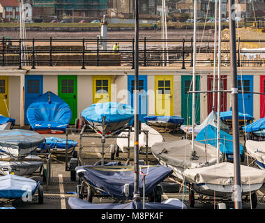 North Berwick, East Lothian, Scozia, Regno Unito, 19 marzo 2018. Vela dinghies al sole in East Lothian Yacht Club con colorate porte dipinte di vecchi bagni cambiando cubicoli. Il cantiere era perviosamente una piscina all'aperto. Foto Stock