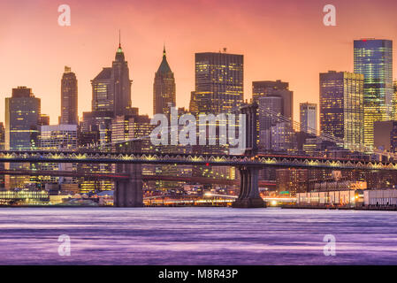 New York, New York, USA la parte inferiore di Manhattan Financial District skyline al tramonto su East River. Foto Stock