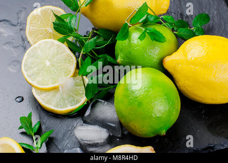 Vista dall'alto di cubetti di ghiaccio e cocktail mojito ingredienti sul nero ardesia bordo, cocktail bevande concept Foto Stock