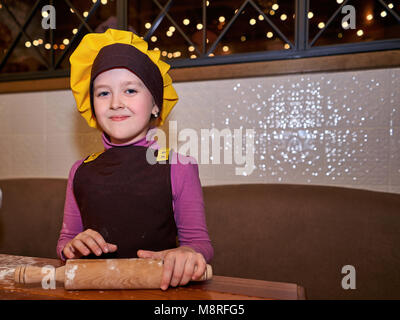 Bambina con il cofano chef ristorante Foto Stock