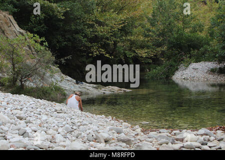 I giovani da soli fata donna vestita di bianco in estate in piedi da solo presso le banche del fiume Acheronte a cancelli di Hades noto dalla mitologia greca Foto Stock