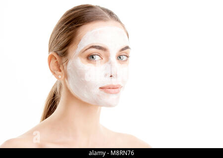 Close-up shot di una giovane e bella donna che indossa una maschera facciale. Isolato su sfondo bianco. Foto Stock