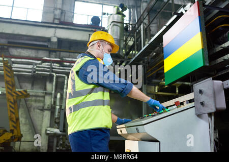 Operatore di macchina al moderno impianto Foto Stock