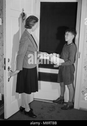 Capitano Charles Wentworth, Junior Commando, consegnando la sig.ra John Farr un foglietto annunciando la raccolta di rottami di metallo e gomma di scarto durante la campagna di salvataggio, Roanoke, Virginia, Stati Uniti d'America, Howard Liberman per ufficio di informazione di guerra, Ottobre 1942 Foto Stock