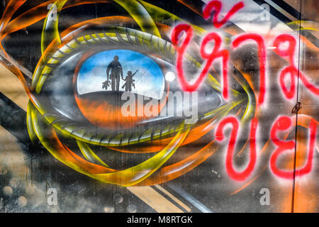 Coloratissimo graffito di un bambino armati a piedi la mano di un adulto in corrispondenza di un muro di casa Foto Stock