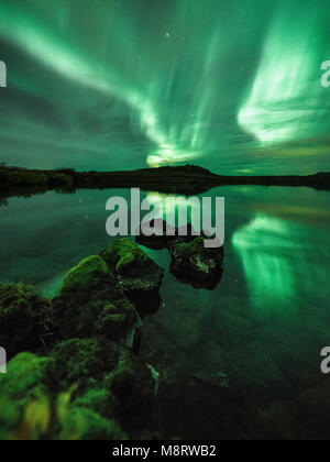 Idillica vista sul lago di contro aurora boreale di notte Foto Stock