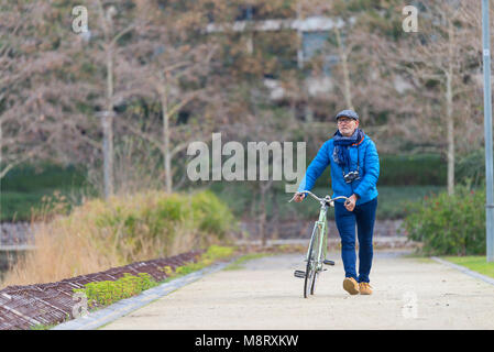 Uomo con passeggiate in bicicletta sul sentiero in posizione di parcheggio Foto Stock