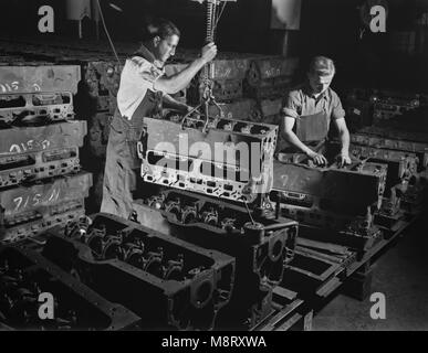 Due lavoratori mettendo i blocchi motore per l'esercito di Scout Half-Track auto sulla linea di assemblaggio in fabbrica convertita alla produzione bellica, White Motor Company, Cleveland, Ohio, USA, Alfred T. Palmer per ufficio di informazione di guerra, Dicembre 1941 Foto Stock