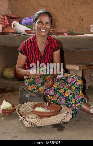 Un locale accogliente dello Sri Lanka donna la preparazione del cibo tradizionale a casa sua - una piccola fattoria appena fuori di Sigiriya. Foto Stock