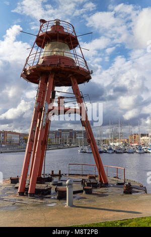 La vecchia guerra luce di navigazione, ora ormeggiata in un porto interno e Marina in Dunkerque, Francia settentrionale. Il Municipio si affaccia sulla Marina B Foto Stock