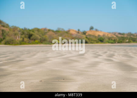 Spiaggia di sabbia closeup sfocata sullo sfondo del paesaggio - Foto Stock