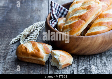 Mini Focaccia pane nella ciotola di legno e spighe di grano sul tavolo di legno Foto Stock