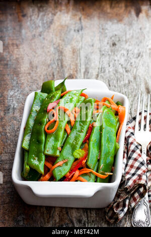 Green fagiolini e carote con spezie sul tavolo di legno Foto Stock