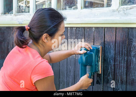 Donna colombiano lavorando su legno con affilatore elettrico Foto Stock