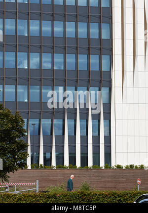 Vista della facciata esterna dal parcheggio con figura di passaggio. 1 Forbury Place, Reading, Regno Unito. Architetto: Aukett Swanke, 2016. Foto Stock