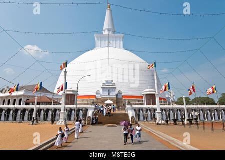 Turisti e pellegrini e persone locali andando al Maha Ruwanmeli Saya Stupa entro il complesso di Anuradhapura Foto Stock