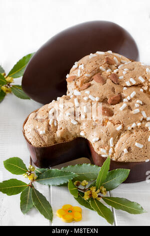 Colomba pasquale, tipico dolce italiano per Pasqua e uovo di cioccolato bianco su sfondo di legno. Foto Stock