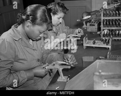 Due Operaie ricondizionamento utilizzata candele per essere riutilizzati nelle prove di aerei militari motori ad impianto Buick convertito per la guerra la produzione del prodotto, Melrose Park, Illinois, Stati Uniti d'America, Ann Rosener, Ufficio di informazione di guerra, Luglio 1942 Foto Stock