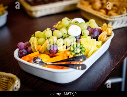 Frutta ciotola buffet al business o nozze luogo dell'evento. Self-service o di tutto quello che potete mangiare la prima colazione dessert con frutta diversa - le uve, melone, Foto Stock