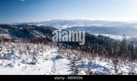 Vista di Beskid Zywiecki mountain range da Ganczorka collina di Beskid Slaski montagne in Polonia durante il congelamento giornata invernale con cielo chiaro Foto Stock