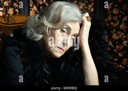 Ritratto di triste donna senior in boa in posa Foto Stock