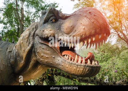 Dinosauro T-rex statua con luce arancione in natura. Foto Stock