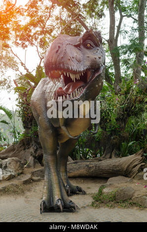 Dinosauro T-rex statua con luce arancione in natura. Foto Stock