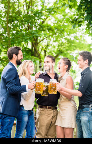 Gli amici o i colleghi sul giardino della birra dopo la tostatura di lavoro con bevande Foto Stock