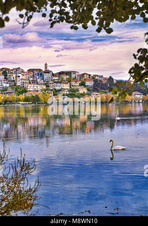Vista panoramica di Kastoria città riflette la tranquilla superficie del lago Orestiada con colori autunnali, in Macedonia Occidentale, Grecia settentrionale Foto Stock