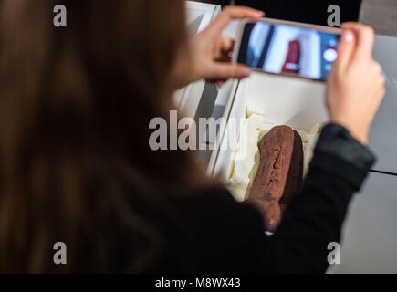 Il 20 marzo 2018, Germania, Monaco di Baviera: un giornalista prende una foto di un artefatto olmeca durante una conferenza stampa del governo bavarese raccolta archeologica. Due artefatti olmeca circa tremila anni sono stati consegnati al governo messicano. I manufatti erano stati presi al di fuori del Messico illegalmente. Foto: Lino Mirgeler/dpa Foto Stock