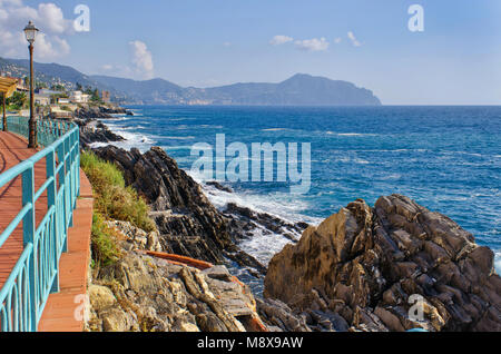 Vista dalla passeggiata sul lungomare di Genova Nervi a la costa ligure e le colline di Portofino in mare su una bella giornata di sole Foto Stock