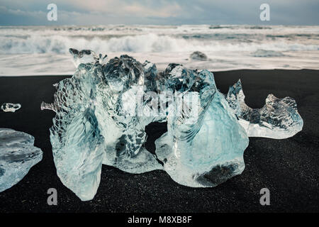 Ghiaccio sul nero spiaggia vulcanica vicino a Jokulsarlon laguna glaciale, inverno Islanda. Dettaglio di un frammento di origine glaciale di ghiaccio in spiaggia di sabbia nera Bella Foto Stock