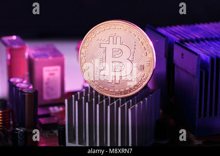 Immagine della moneta virtuale, bitcoin e processore su sfondo rosa Foto Stock