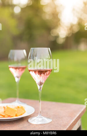 Due bicchieri di vino rosato su un tavolo per esterno Foto Stock