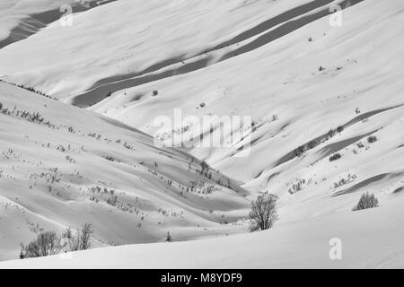 Snow blanketing il Talkeetna montagne a Hatcher Pass crea forme fluenti nel tardo inverno in Alaska centromeridionale. Foto Stock