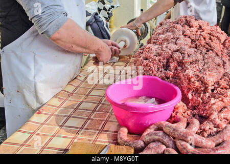 Il macellaio rende salsicce fatte in casa all'aperto in un modo tradizionale. Foto Stock