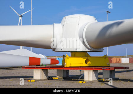 Giant di rotori di turbine eoliche nel mulino a vento cantiere di attesa per il trasporto ai parchi eolici offshore in mare, sotto il cielo blu Foto Stock