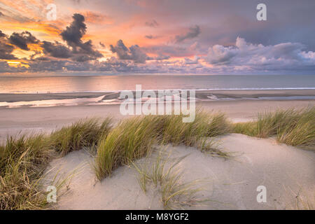 Vista tramonto dalla cima di dune oltre il mare del Nord e il canale in Zeeland, Paesi Bassi Foto Stock