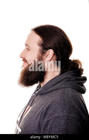 Vista laterale del bello uomo barbuto con i capelli lunghi in abiti casual, su sfondo bianco, vicino. Foto Stock
