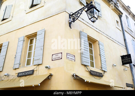 Scena di strada in Arles, giallo tipico edificio rustico con la luce blu scuri su windows e lampione, Provenza, Francia Foto Stock