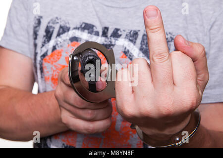 Mano maschio rapinatore in manette con una pistola isolato su uno sfondo bianco Foto Stock